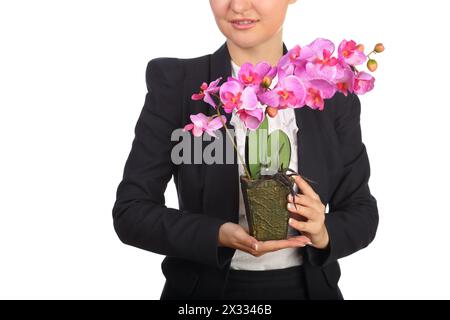 Frau im schwarzen Anzug, die einen Blumentopf mit künstlicher Blumenorchidee hält Stockfoto