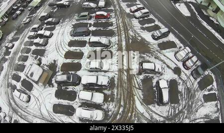 Autos auf dem Parkplatz mit Schnee bedeckt, aus der Vogelperspektive Stockfoto