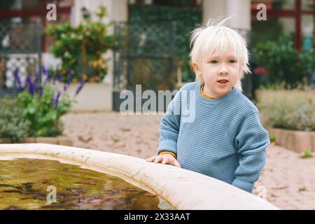 Außenporträt eines entzückenden kleinen Jungen, der draußen spielt Stockfoto