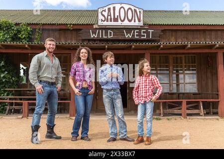 Vierköpfige Familie auf dem Hintergrund des Wildwest-Salons Stockfoto