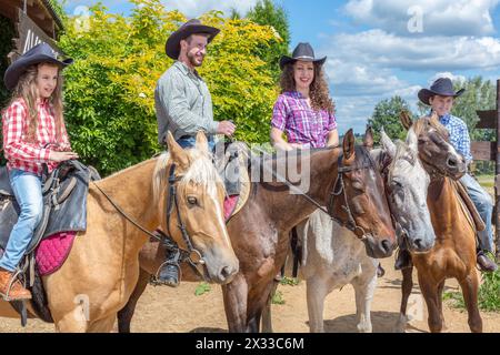 Vierköpfige Cowboyfamilie auf Pferden Stockfoto