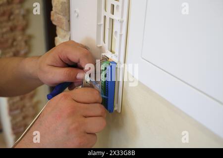 Ein Elektriker installiert eine Steckdose in einem frisch renovierten Apartment Stockfoto