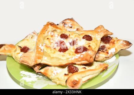 Blätterteigkekse mit Hüttenkäse und Beeren liegen auf einem Teller. Stockfoto