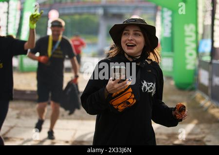 Glückliches junges ukrainisches Mädchen, das den Lauf beim Spartan Race Competition in Kiew am 20. April 2024 beendet Stockfoto