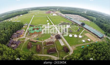 RUSSLAND, BOROVSK - 13. Juni 2014: Aus der Vogelperspektive von Touristen spazieren durch das Territorium des Kulturkomplexes Ätnomir beim Ethnofestival Wild Mint. Foto mit Rauschen Stockfoto