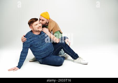 Zwei Männer sitzen friedlich übereinander. Stockfoto