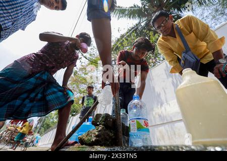 Dhaka, Bangladesch. April 2024. Während des heißen Sommertages sammeln Bangladesch am 22. April 2024 Trinkwasser aus einer Wasserversorgung am Straßenrand in Dhaka, Bangladesch. In der Hauptstadt Dhaka erreichte die Temperatur am 16. April 40Â °C (105Â °Fahrenheit), die höchste seit 58 Jahren, was das Leben der Menschen bei geringer Luftfeuchtigkeit länger als eine Woche unerträglich machte, so die Beamten des Meteorologischen Departements von Bangladesch (BMD). Fünf Arten von Gasschichten wurden in Dhakas Luft erzeugt. Diese Gase wurden aus Müllhalden, Ziegelöfen, Fahrzeugen und dem erzeugt Stockfoto