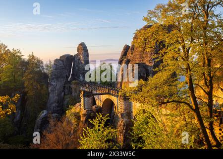 Sonnenaufgang in der Sächsischen Schweiz die Bastei ist eine Felsformation mit Aussichtsplattform in der Sächsischen Schweiz am rechten Ufer der Elbe auf dem Gebiet der Gemeinde Lohmen zwischen dem Kurort Rathen und Stadt Wehlen. Sie zählen zu den meistbesuchten Touristenattraktionen der Sächsischen Schweiz. .Ferdinandaussicht mit Blick auf die Basteibrücke von 1851. Rathen Sachsen Deutschland *** Sonnenaufgang in der Sächsischen Schweiz die Bastei ist eine Felsformation mit einer Aussichtsplattform in der Sächsischen Schweiz am rechten Elbufer in der Gemeinde Lohmen zwischen dem Kurort Rathen und Stockfoto