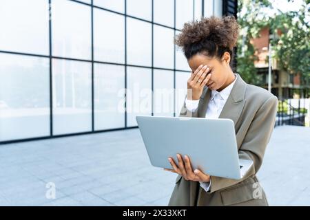 Porträt junger erfolgreicher Geschäftsfrau Büroangestellter mit Laptop-Computer außerhalb des Bürogebäudes in formeller Kleidung. Professionelles weibliches Business-pe Stockfoto
