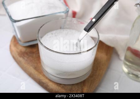 Chemische Reaktion von Essig und Backnatron in Glasschale auf weißem Tisch, Großaufnahme Stockfoto