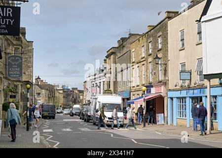 Tetbury, Gloucestershire, England, Vereinigtes Königreich - 13. April 2024: Besucher der historischen ländlichen Stadt Tetbury über eine Straße im Stadtzentrum. Stockfoto