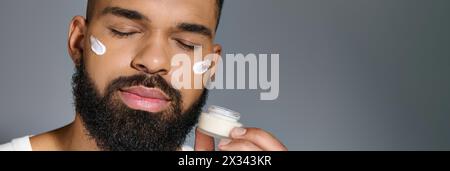 afroamerikaner, schöner junger Mann, der Creme auf sein Gesicht aufträgt. Stockfoto