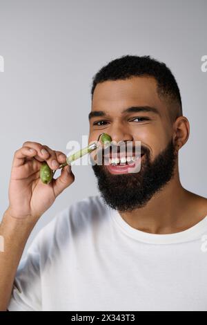 afroamerikaner ansprechender Mann hält Gesichtsrolle für Hautpflege-Routine. Stockfoto