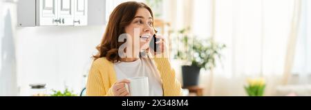 Eine stilvolle Frau mittleren Alters spricht mit ihrem Handy, während sie eine Kaffeetasse hält. Stockfoto