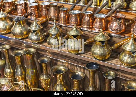 Türkische Kaffeekocher und Vasen mit geprägten Mustern stehen in Reihen auf dem Theken eines Straßenbazars in Buchara Stockfoto