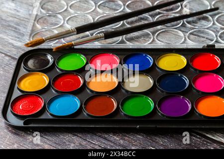 Eine Palette von Farben für Aquarellkunst. Zwei Künstler-Pinsel lagen an der Palette. Stockfoto