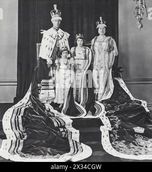 Dieses Foto zeigt die königliche Familie in ihren zeremoniellen Gewändern am Tag der Krönung von König Georg VI. Von rechts nach links sind König George VI., Prinzessin Margaret, Prinzessin Elizabeth und Königin Elizabeth. Dieses historische Bild spiegelt einen wichtigen Moment für die britische Monarchie wider und zeigt die Einheit der Familie und die feierliche Feier des Anlasses. Stockfoto