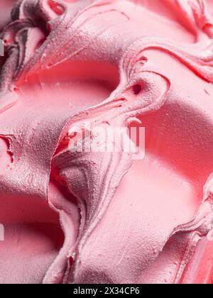 Gefrorenes Eis mit Himbeergeschmack – Vollformatdetail. Nahaufnahme einer rosafarbenen Oberflächenstruktur von Eiscreme. Stockfoto