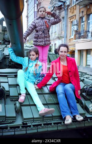 Frau und zwei Mädchen posieren auf einem großen Panzerpanzer in Samara während einer Militärparade in Russland Stockfoto