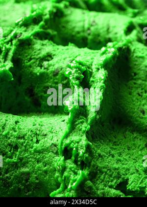Gefrorenes Eis mit Cannabisgeschmack – Vollformatdetail des Sorbets. Nahaufnahme einer grünen Oberflächenstruktur von Eis gefüllt mit Stücken gemischter Früchte. Stockfoto
