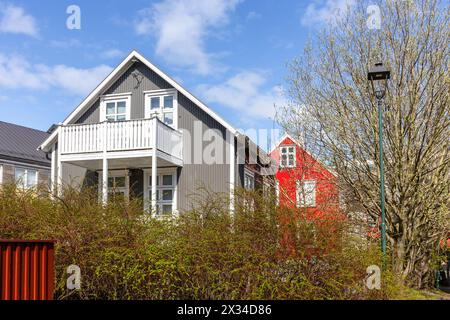 Wohnviertel in Reykjavik, Island, mit traditionellen isländischen Eisenhäusern mit Giebeldach, weißen Fensterrahmen und weißem Holzbalkon Stockfoto