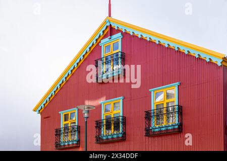 Traditionelles isländisches, roteisenverkleidetes Wohngebäude mit bunten Fensterrahmen und dekorativem Dach und Balkonen, Reykjavik, Island. Stockfoto