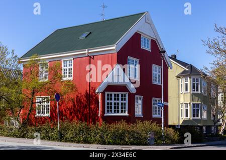 Traditionelle isländische rot-grüne Wohngebäude mit Giebeldächern, weißen Fensterrahmen, verkleidet mit Wellblechen in Reykjavik. Stockfoto