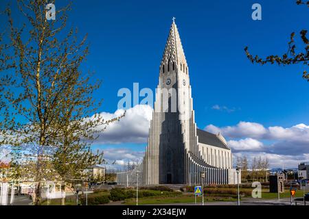 Reykjavik, Island, 14.05.22. Hallgrimskirkja modernistische Kirche, die an Basaltsäulen in Reykjavik, Island, auf dem Hügel Skolavorduholt mit Bäumen erinnert. Stockfoto