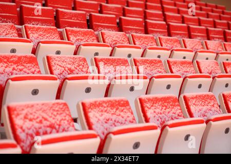 Reihen von hellen Sitzreihen von Tribünen bedeckt mit Schnee auf dem Stadion Stockfoto