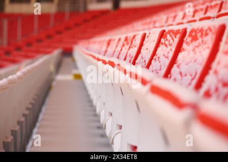 Viele Reihen von hellen Tribünen bedeckt mit Schnee auf dem Stadion Stockfoto