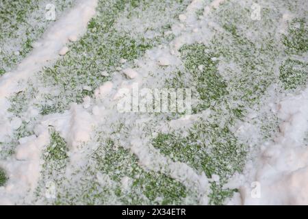 Schnee auf künstlichem Grünrasen im Fußballstadion, Nahaufnahme Stockfoto