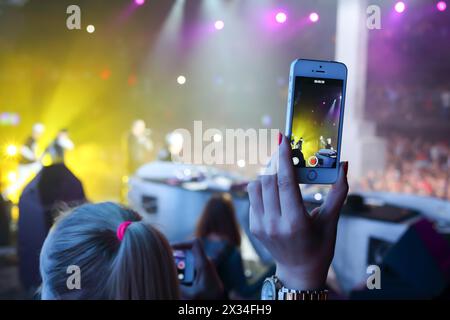 MOSKAU, RUSSLAND - 15. NOVEMBER 2014: Weibliche Hand mit Telefon entlastet Konzert auf einer Party Diskach 90. In einem Club Space Moscow Stockfoto