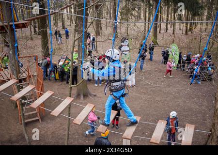 Junge gekleidet und ausgerüstet für Klettertouren über die Seilbrücke im Wald. Stockfoto