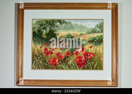 Landschaft, gestickt auf Stoff, in einem Holzrahmen an der Wand. Stockfoto