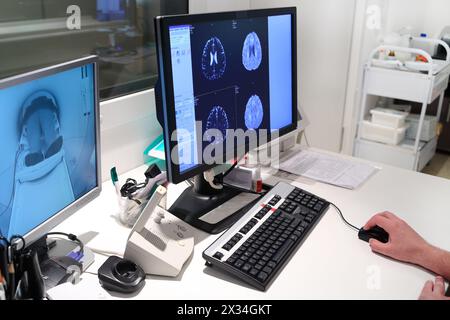 MRT-Untersuchung des Gehirns am Monitor im Kontrollraum und bei der Überwachung des Patienten Stockfoto