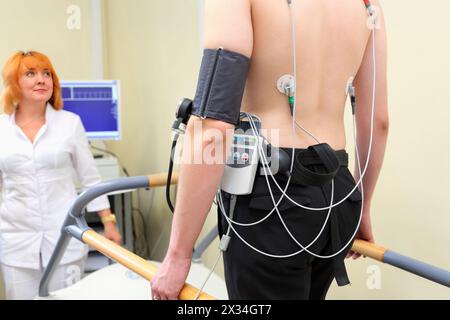 Arzt hält EKG-Mann während der Bewegung, in der multidisziplinären Klinik Endochirurgie und Lithotripsie Stockfoto