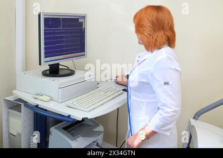 Pflegekraft untersucht Kardiogramm des Patientenmonitor-EKG in der multidisziplinären Klinik Stockfoto