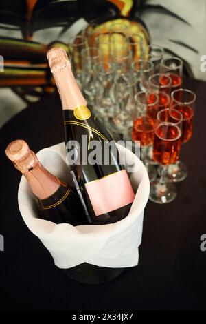 Gläser mit Rosenwein und zwei Flaschen im Eiskübel Stockfoto