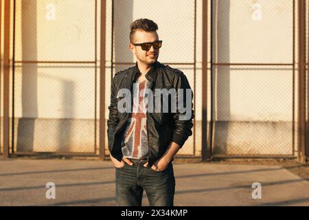 Hipster in schwarzer Lederjacke und Sonnenbrille. Porträt Bei Sonnenuntergang Im Freien. Stockfoto