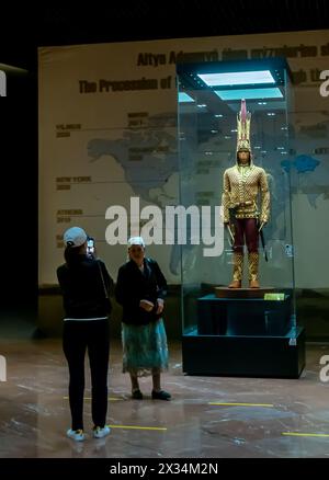 Besucher posieren vor Golden man, einem jungen edlen Saka-Krieger, 5-4. Jahrhundert v. Chr. Wiederaufbau von Kleidung und Ausrüstung, Museum in Astan Stockfoto