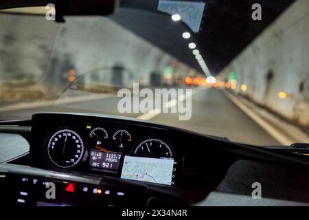 Blick durch die Windschutzscheibe des Autos, das sich im Tunnel auf der Straße bewegt. Stockfoto
