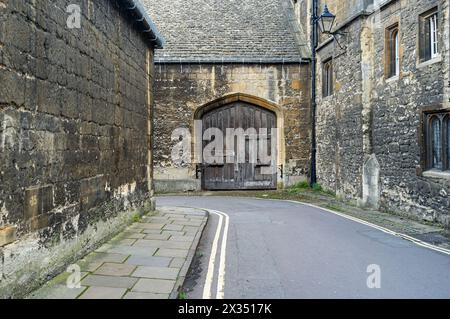 Alte mittelalterliche Gasse in England mit Steinbau und Holztor Stockfoto