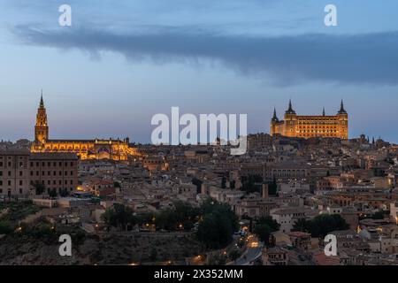 Ein Panorama der spanischen Stadt Toledo in der Dämmerung, mit dem markanten beleuchteten Alcázar von Toledo und der gotischen Kathedrale von Toledo Stockfoto