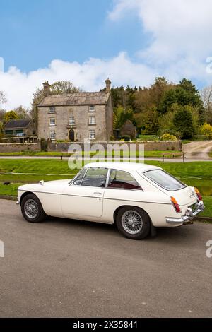 1967 Oldtimer MG B GT parkt am Dorfteich im Dorf Hartington, England, Großbritannien Stockfoto