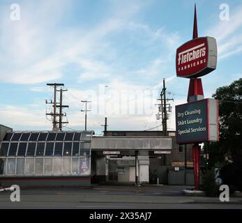 Klassische chemische Reinigung im Einzelhandel aus den 1960er Jahren mit Drive-in-Eingang und klassischem, drehbarem Leuchtschild. Stockfoto