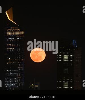 Kuwait City, Kuwait. April 2024. Der Mond steigt am 24. April 2024 zwischen Wolkenkratzern in Kuwait City auf. Quelle: Asad/Xinhua/Alamy Live News Stockfoto