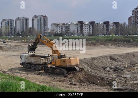 Der Bagger lädt ausgehobenen Boden in einen großen Lkw in einem bewohnten Gebiet Stockfoto