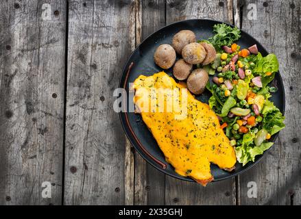 Gebratene Forelle in Zwiebelsauce - frischer Salat mit gebackenen Kartoffeln Stockfoto