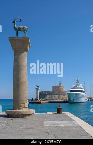 Elafos und Elafina, Hirsch und Hintern, Skulpturen auf Säulen, Hafeneingang Mandraki Hafen, Festung Agios Nikolaos mit Leuchtturm, Rhodos Stockfoto