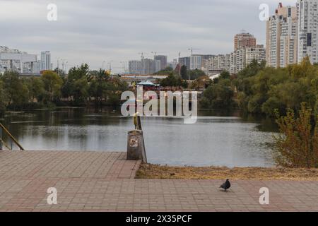 Ein ruhiger See, eingebettet zwischen städtischen Gebäuden und üppigen Bäumen unter einem bewölkten Himmel Stockfoto
